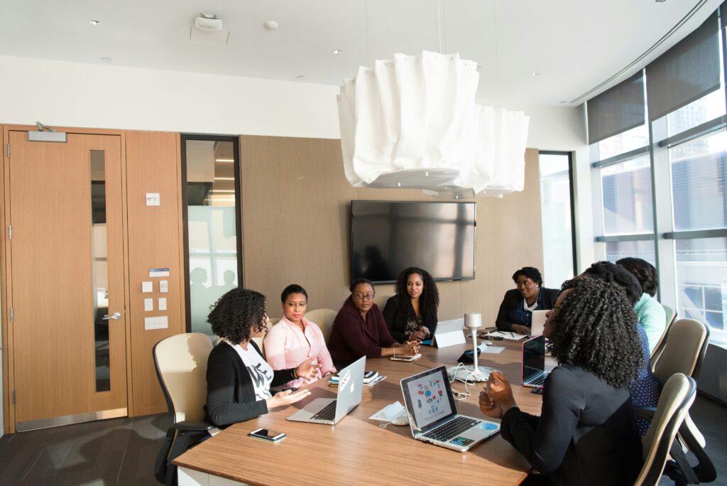 a group of women having a meeting in a light-filled, modern meeting room